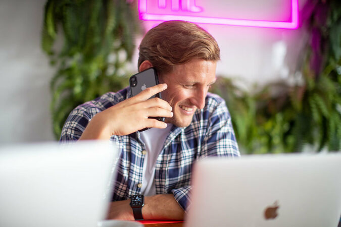 A member of the moxie team answering a phone whilst sat at a work desk
